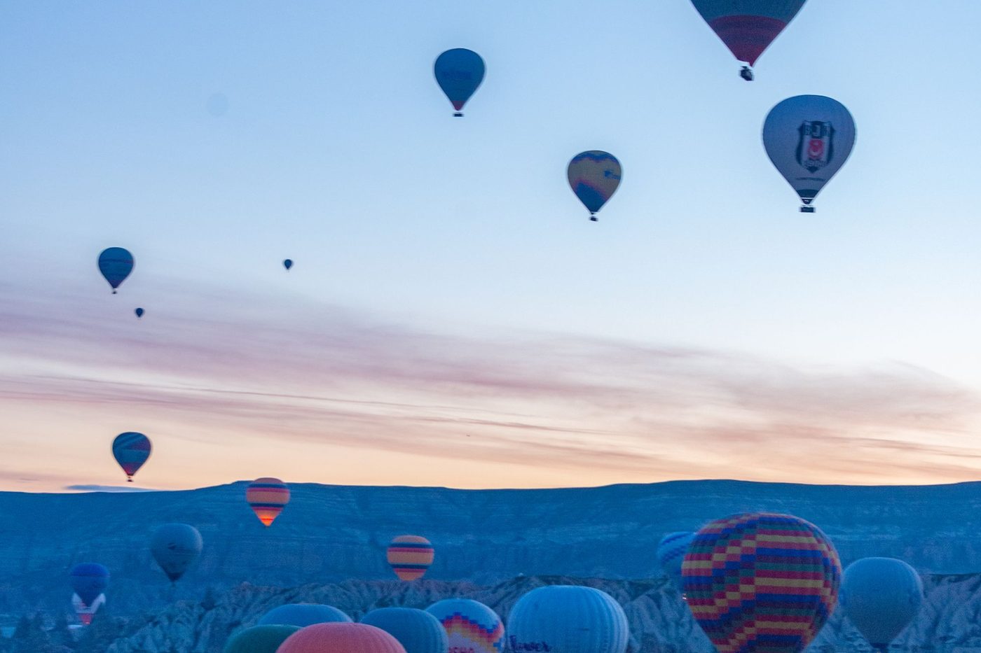 Hot air balloons rising over the Goreme valley at dawn, Cappadocia